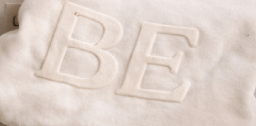 Close detail of raised BE puff embroidery on cream fleece